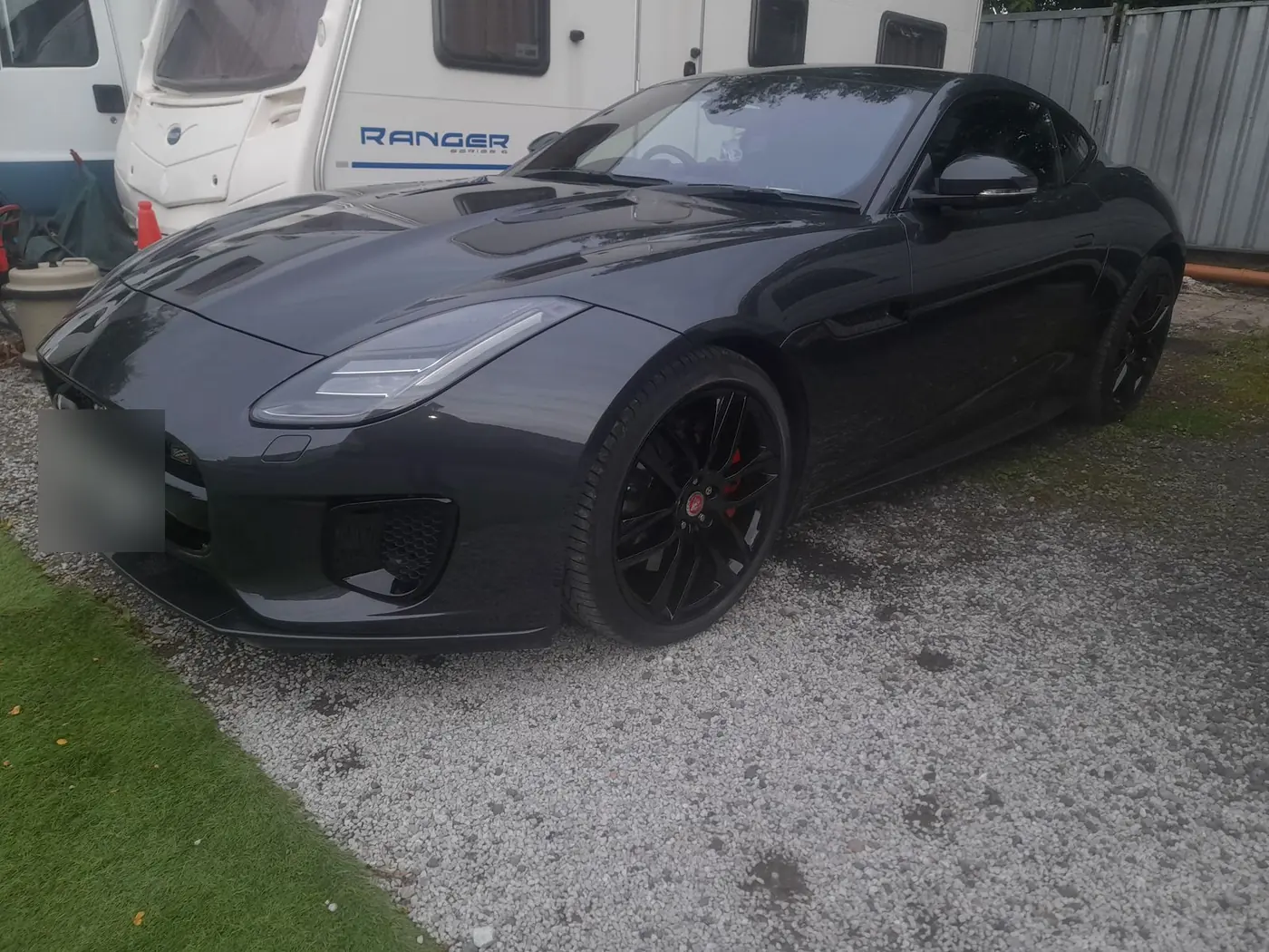 A black Jaguar F-Type on gloss black wheels