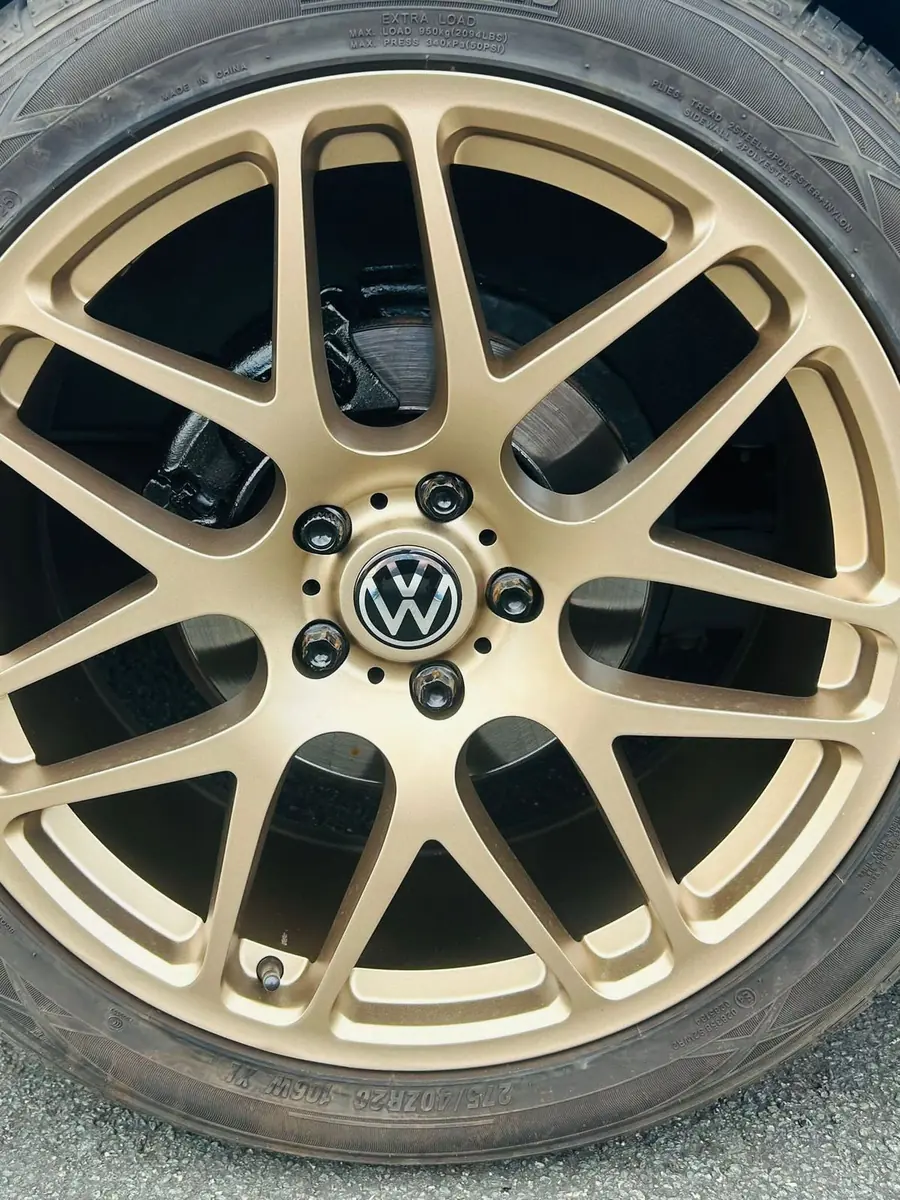 A gold Volkswagen wheel, close up
